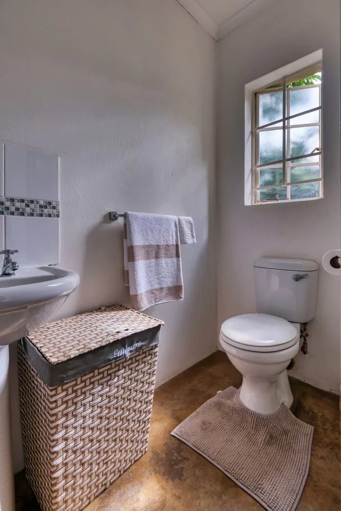 Bathroom with a wicker laundry basket beside the window