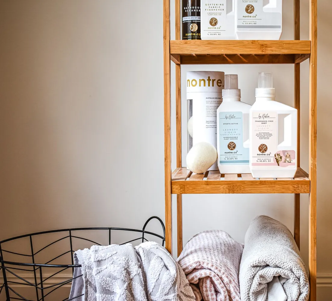 Bathroom towels and toiletries arranged on bamboo shelves