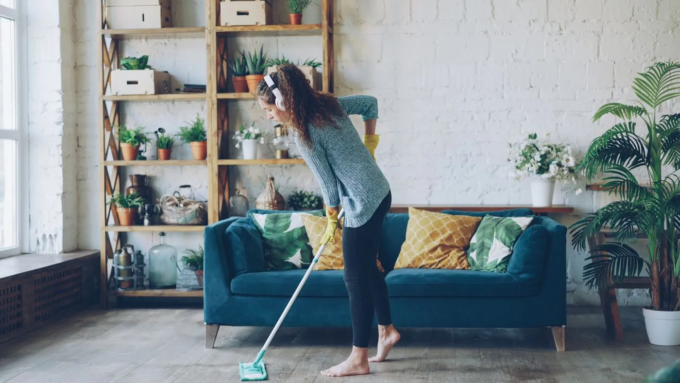 Person mopping a furnished living room