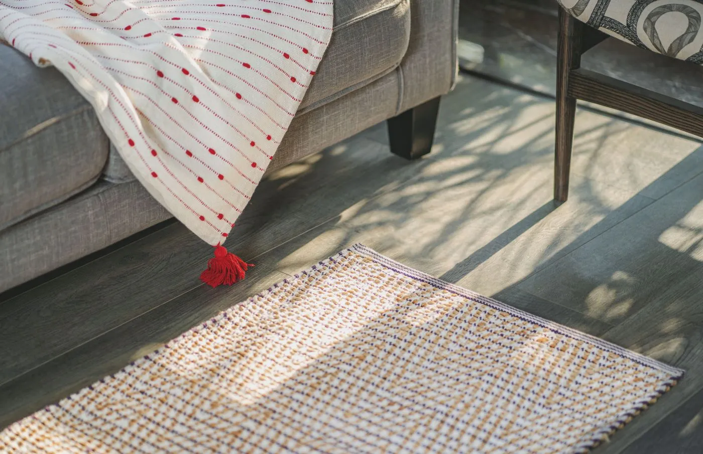 Textured rug and throw blanket beside a gray sofa