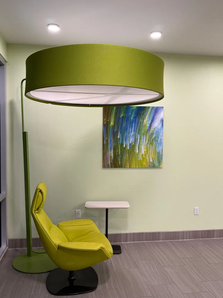 Green chair and lamp against a pale wall