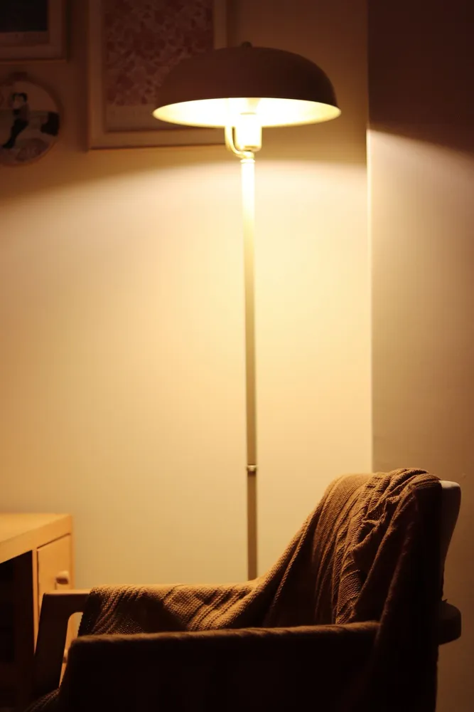 Armchair beside a glowing lamp in a quiet corner