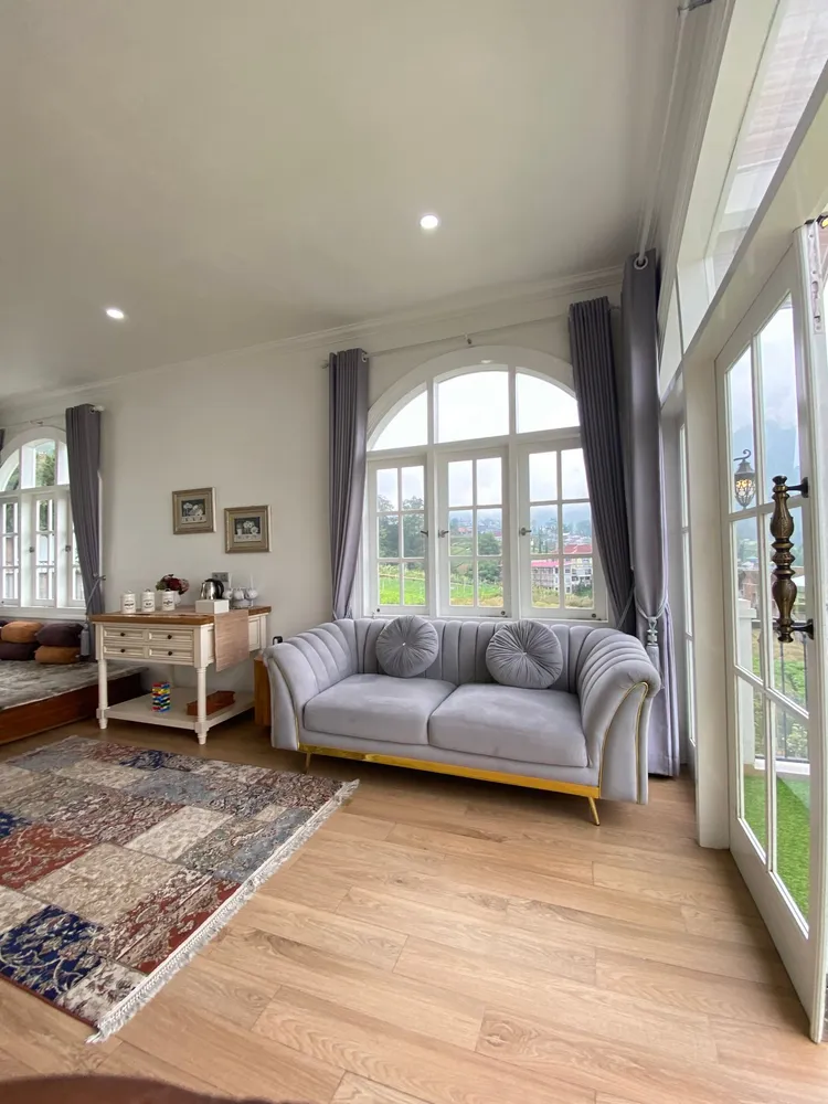 Sunlit living room with a sofa and large windows