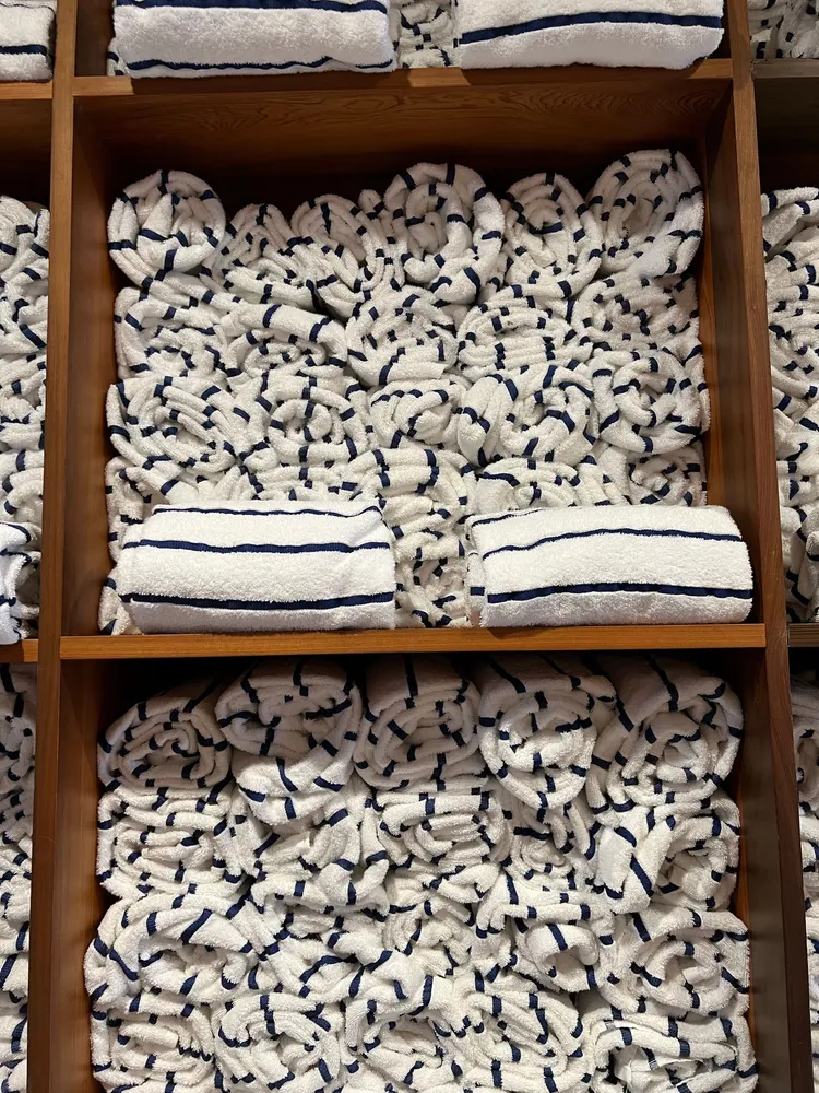 Rolled striped towels arranged on wooden shelves